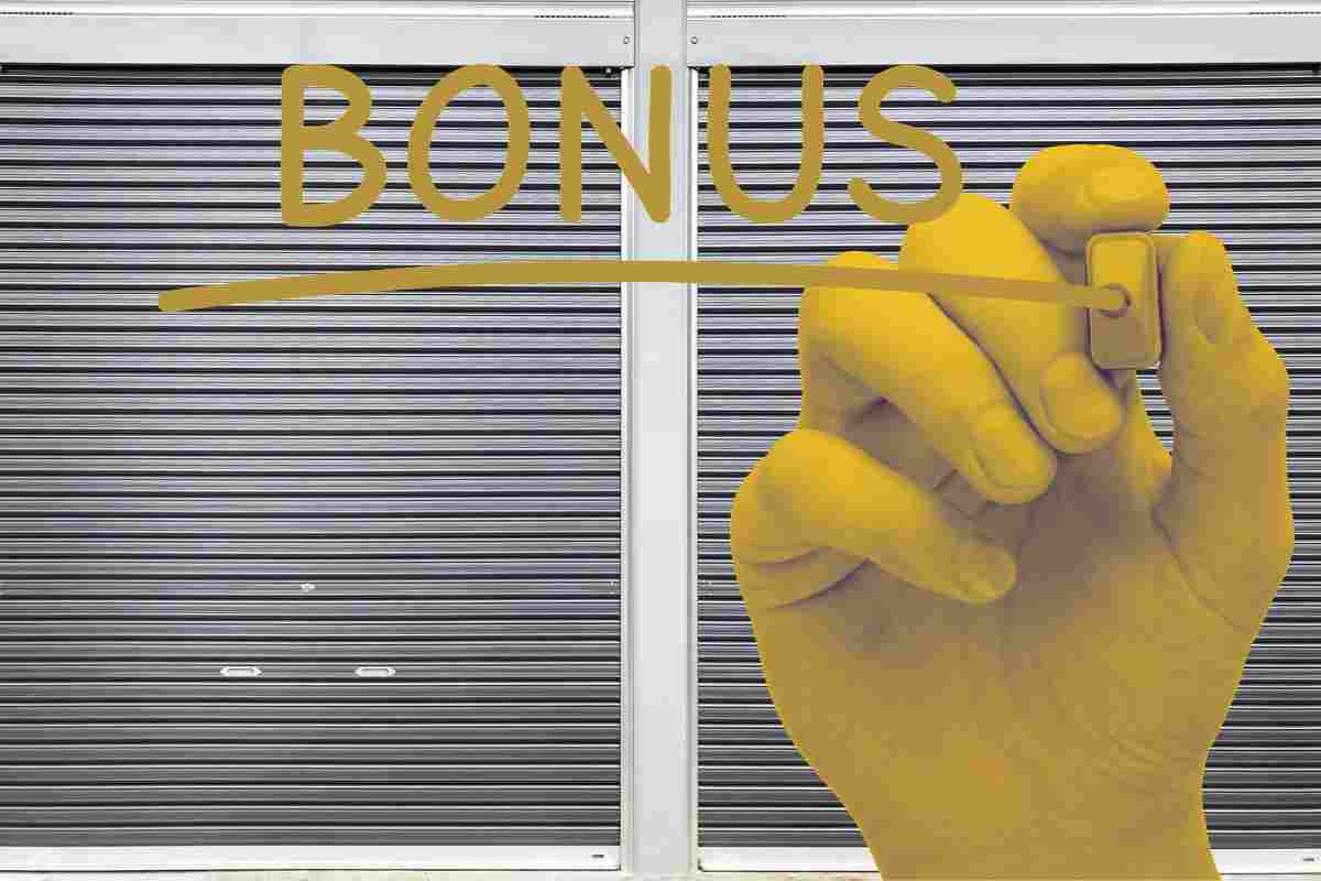 mano dorata scrive la parola bonus e sullo sfondo un garage chiuso