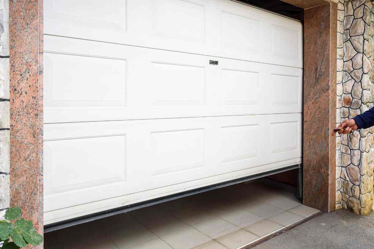 una mano apre un garage col telecomando