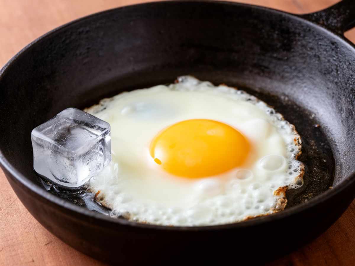 padella con dentro uovo fritto e cubetto di ghiaccio